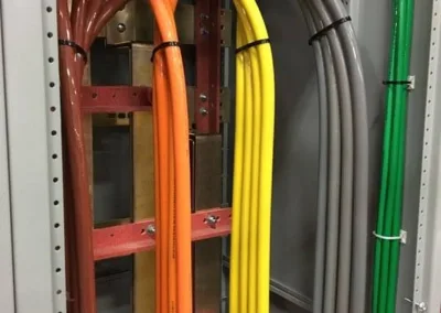 Color-coded conduits organized in an electrical cabinet.